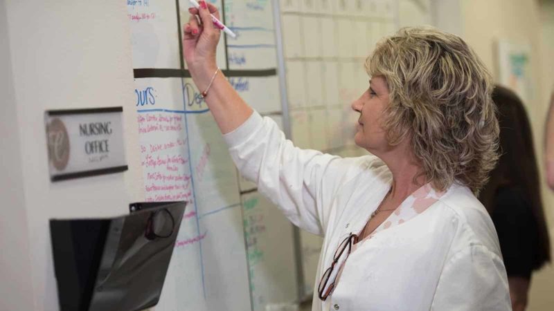 Nurse writing on whiteboard